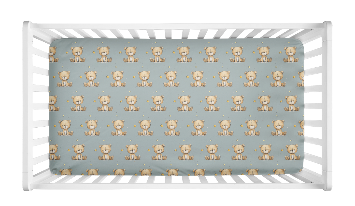 Sage green crib sheet with repeating teddy bear and star pattern in crib