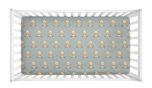 Sage green crib sheet with repeating teddy bear and star pattern in crib