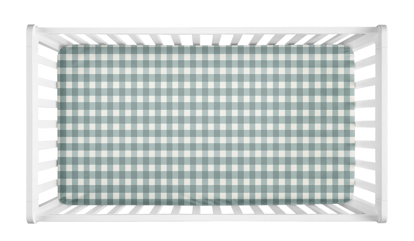 Sage green gingham baby crib sheet inside white crib