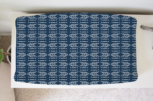 Navy mud cloth arrow print changing pad cover on white dresser in a nursery setting