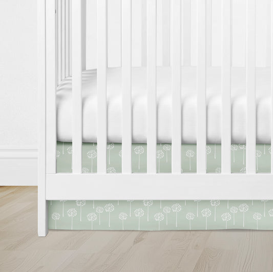 crib skirt with sage green dandelion print, adding a soft, whimsical touch to a white crib.