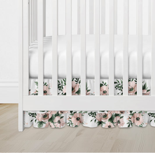 Ruffled crib skirt in blush pink floral pattern with greenery on white background