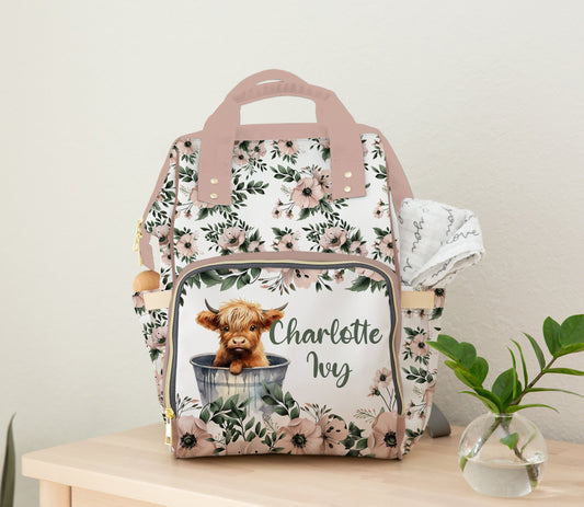 Personalized floral diaper bag backpack with Highland cow and the name  on the front pocket.