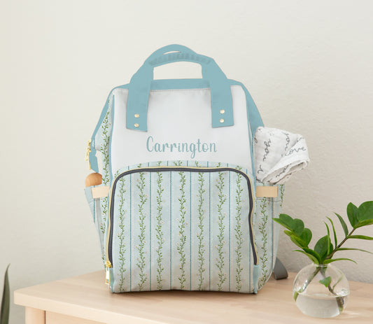 Light blue and white floral stripe diaper bag backpack with front zipper pocket and insulated side bottle holders.
