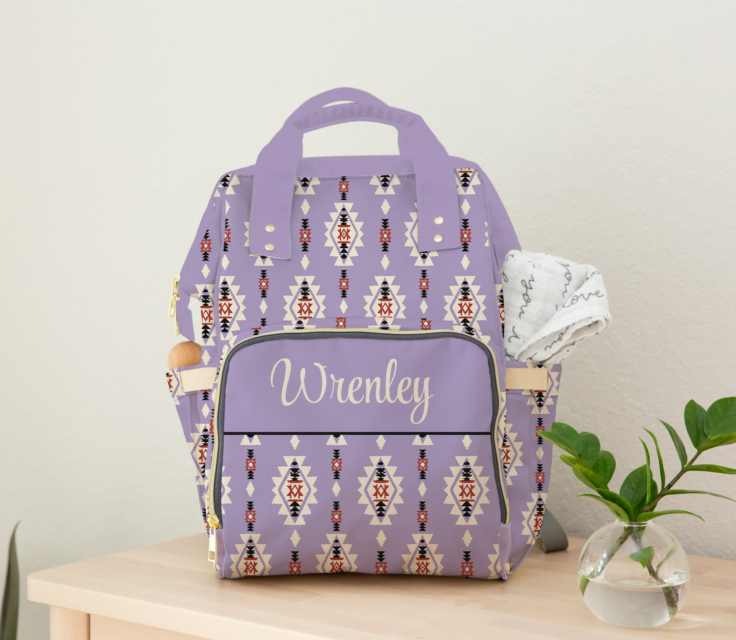 Personalized purple Aztec diaper bag backpack with custom name on front pocket, lavender handles, side pockets, and western-inspired geometric pattern.